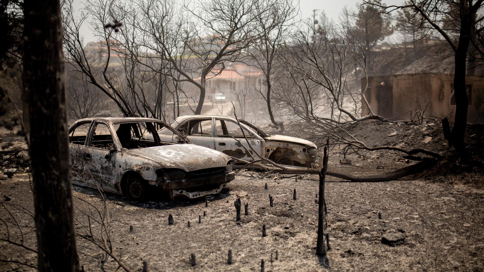 Verbrannte Autos stehen nach einem Waldbrand im Dorf Kiotari. Auf Rhodos und in anderen Teilen Griechenlands toben als Folge einer enormen Hitzewelle Waldbrände.