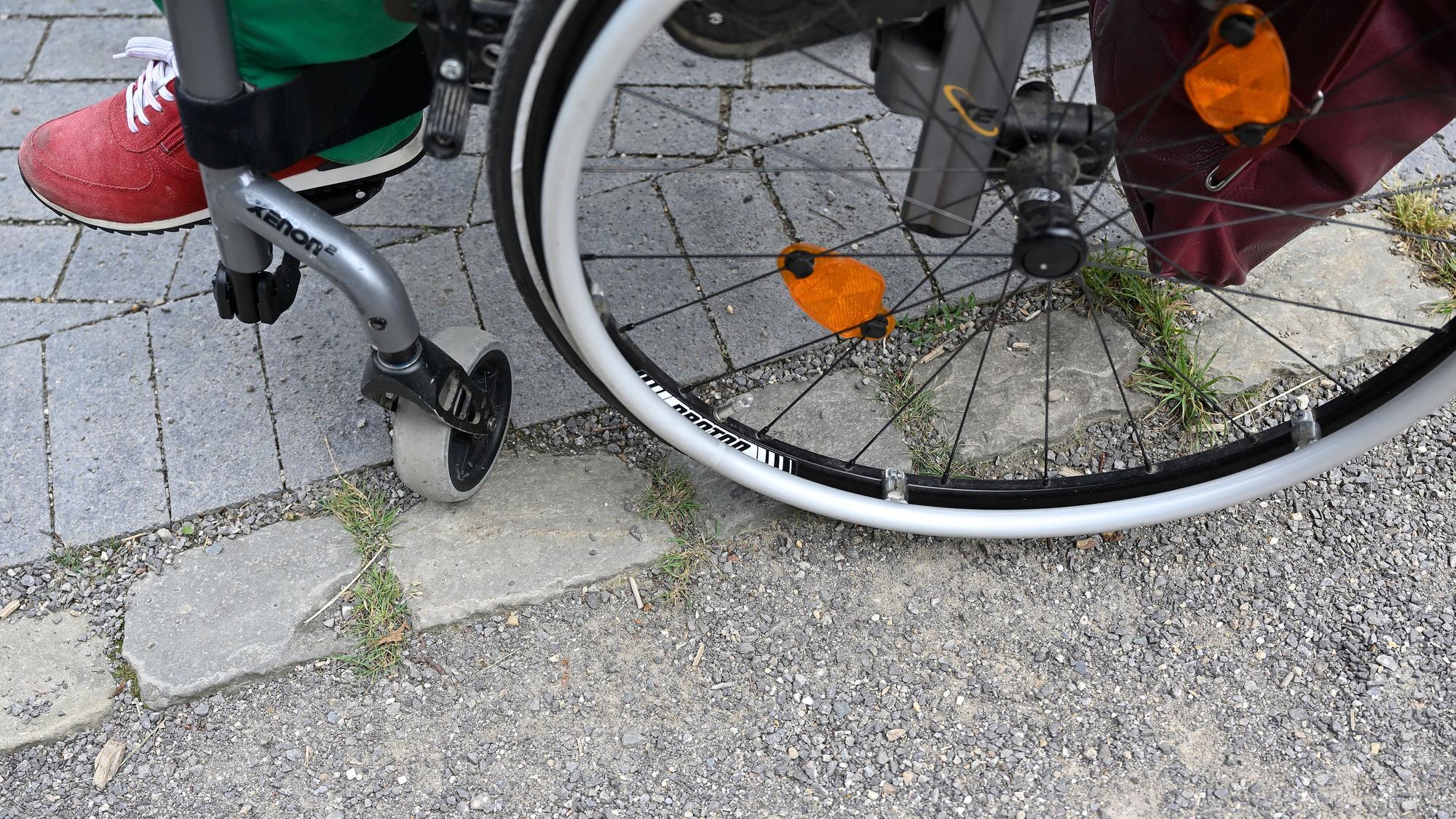 Ein Rollstuhl hat Schwierigkeiten, mit seinen Rädern die Kanten von Pflastersteinen zu überwinden.