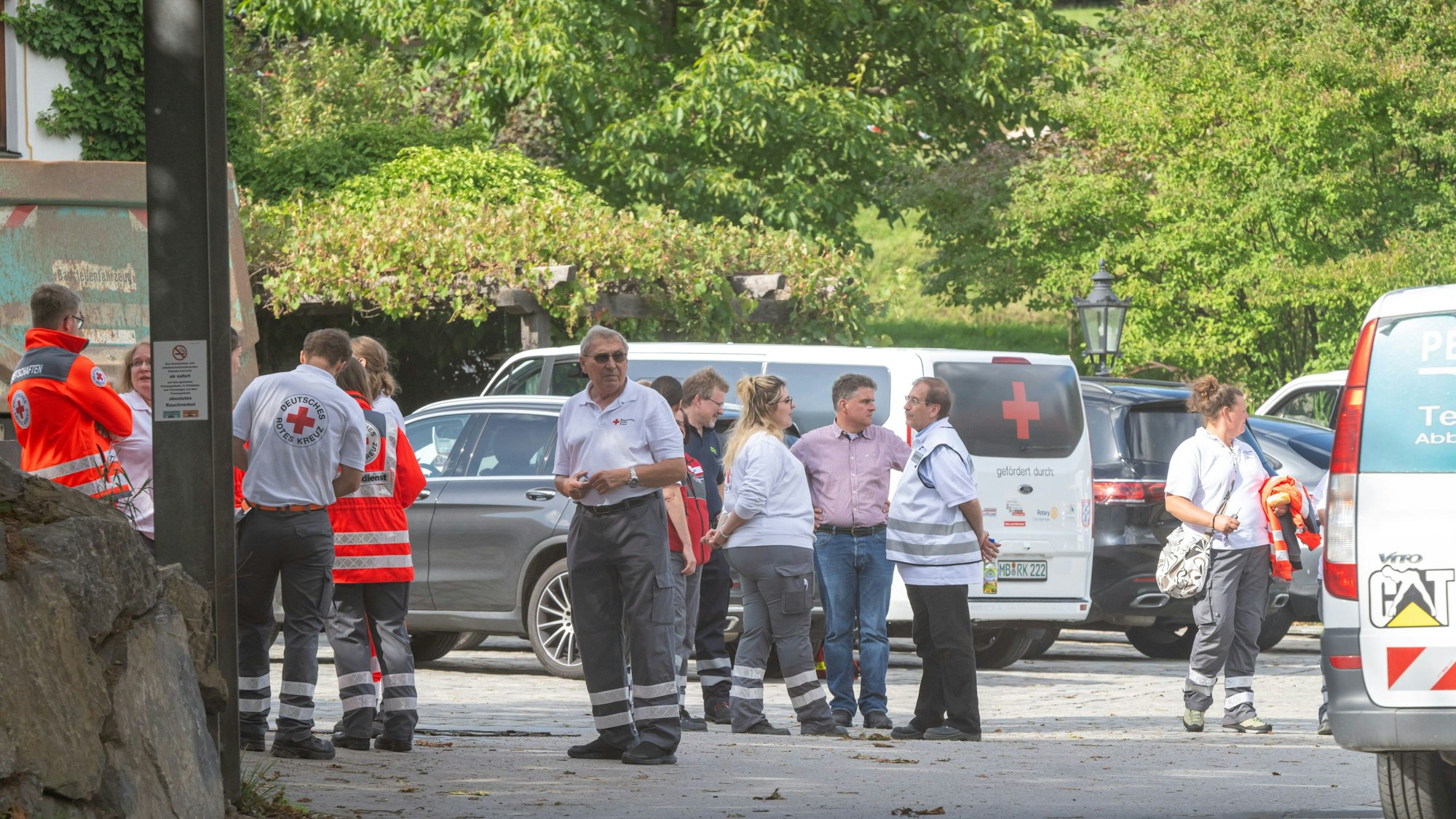 Bayern, Weyarn: Diverse Helfer stehen in der Einfahrt des Unternehmens.