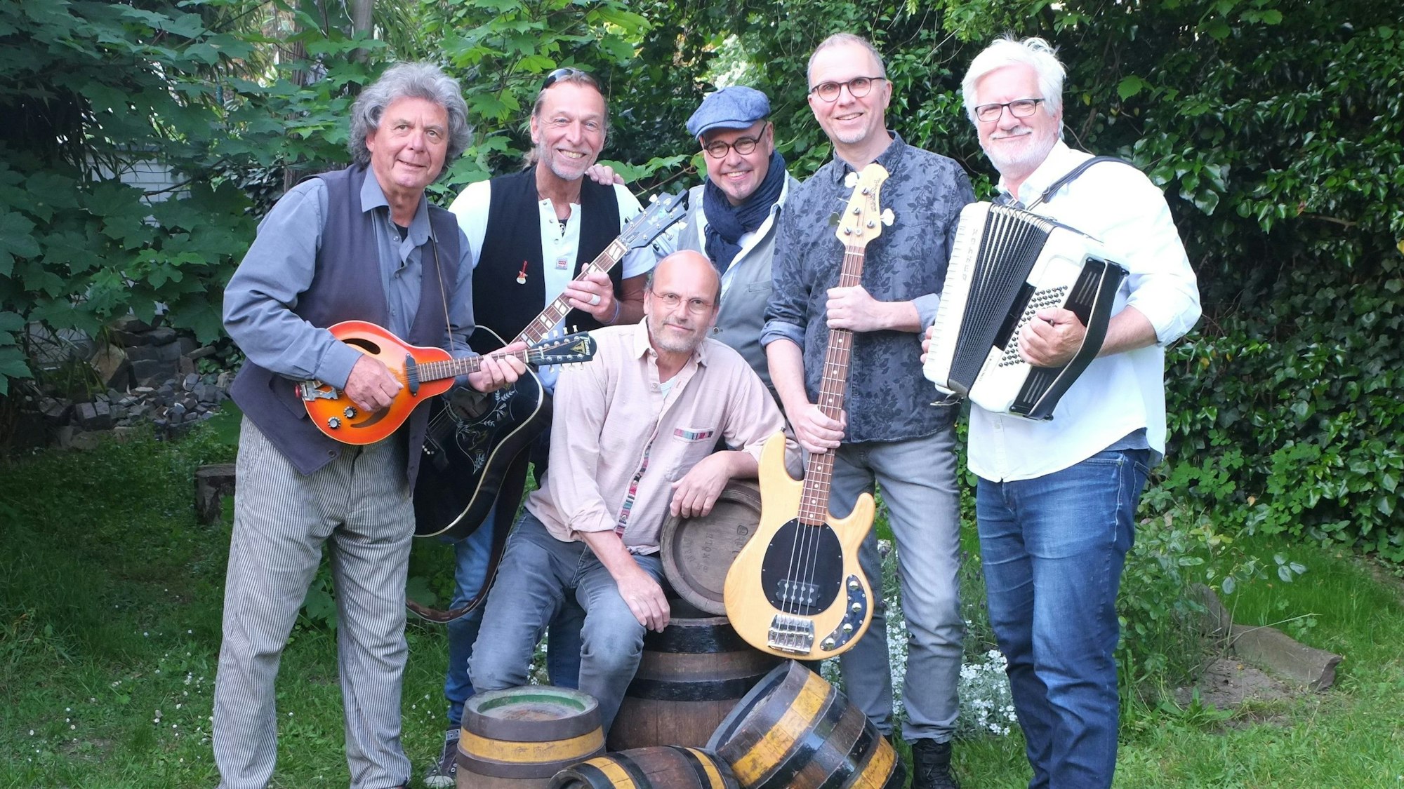 Sechs Männer halten Musikinstrumente in den Händen