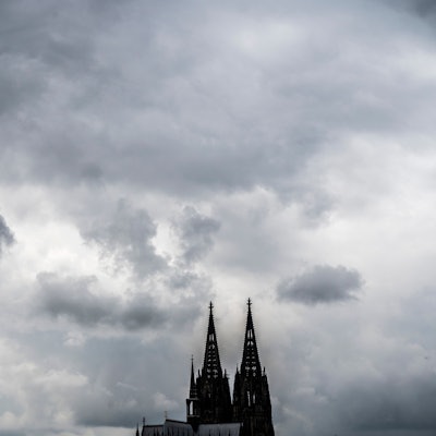 Eine leitende Mitarbeiterin des Erzbistums Köln hat ein wegweisendes Urteil gegen ihren Arbeitgeber erstritten. Unser Bild zeigt den Dom vor dunklen Wolken.