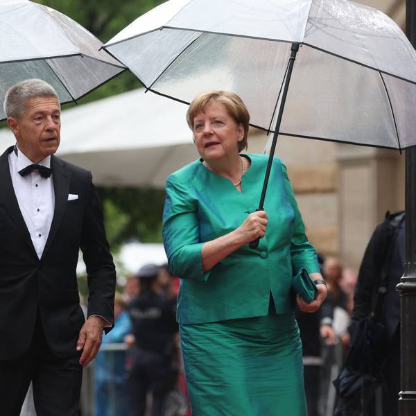 Bayern, Bayreuth: Ex-Bundeskanzlerin Angela Merkel (CDU) und Ehemann Joachim Sauer kommen mit Regenschirm zur Eröffnung der Richard-Wagner-Festspiele.