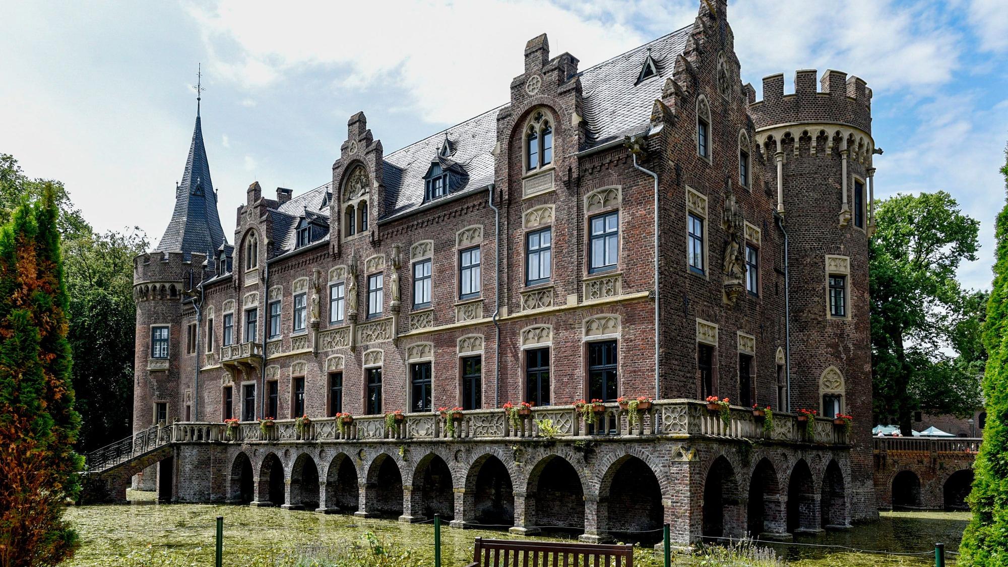 Mit vielen Zinnen, Türmchen und Balustraden bietet Schloss Paffendorf einen malerischen Anblick inmitten seines Burggrabens.