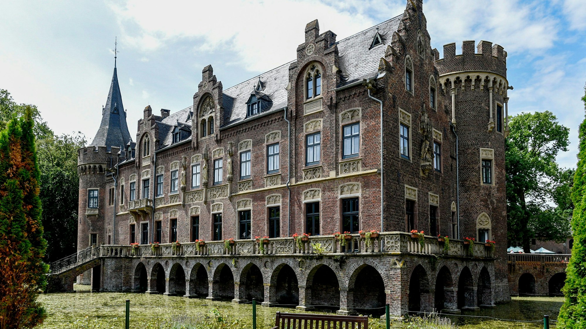 Mit vielen Zinnen, Türmchen und Balustraden bietet Schloss Paffendorf einen malerischen Anblick inmitten seines Burggrabens.