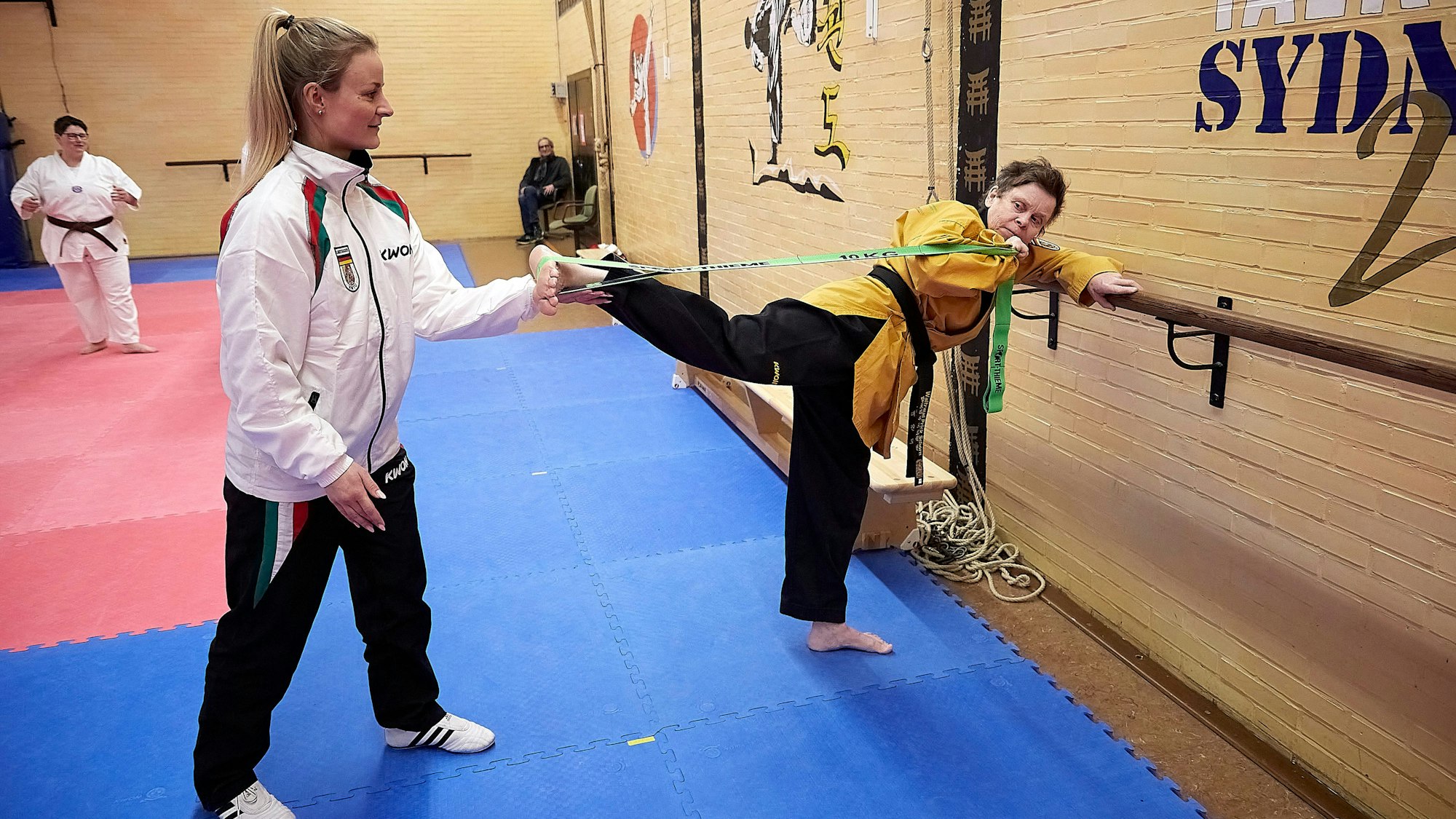 Trainerin Jessica Rau und koorigiert bei einer Übung ihren Schützling bei der Haltung.