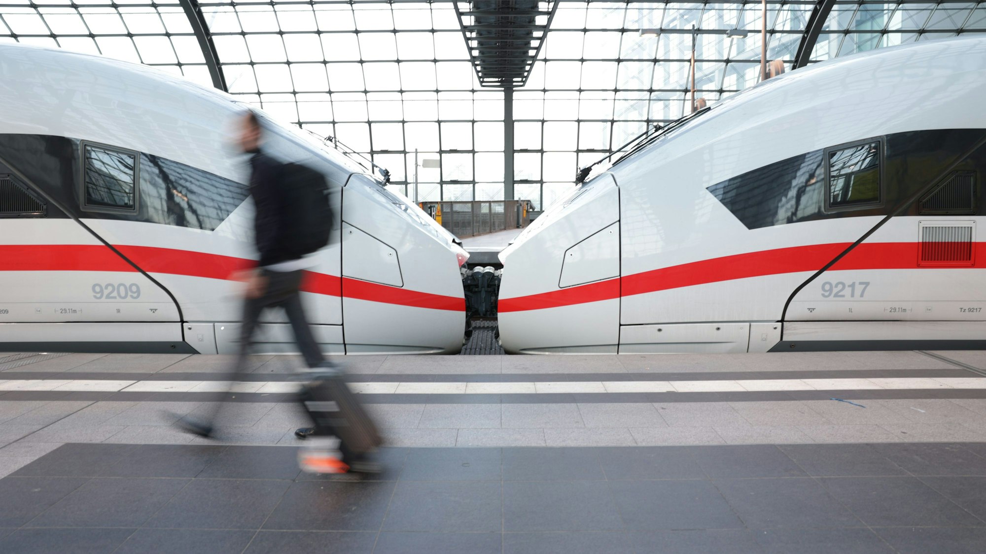 ARCHIV - 11.07.2022, Berlin: Reisende eilen am frühen Morgen zu einem ICE am Hauptbahnhof.