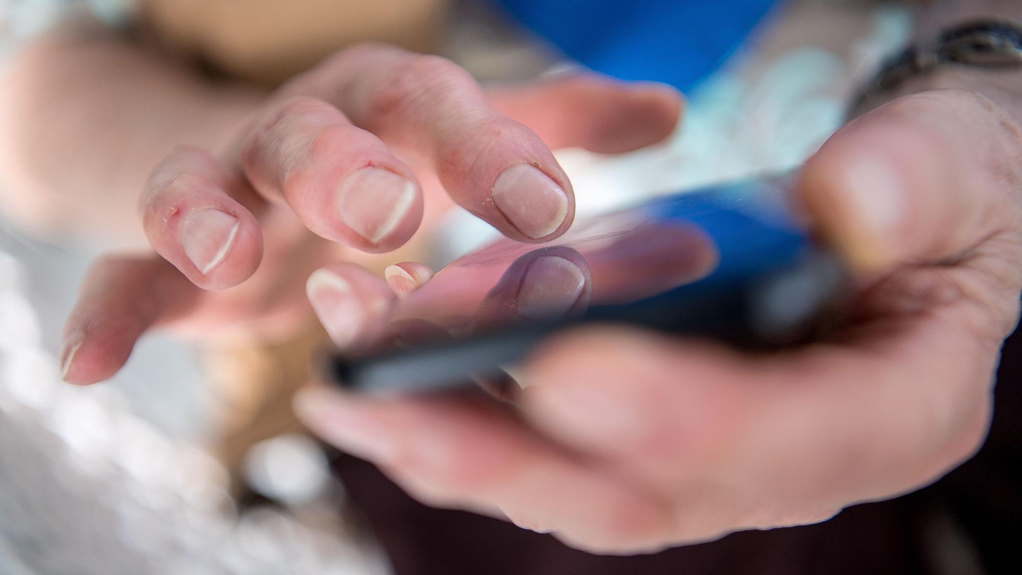 Das Foto zeigt, wie eine Seniorin auf ihrem Smartphone tippt. Die Szene ist gestellt.