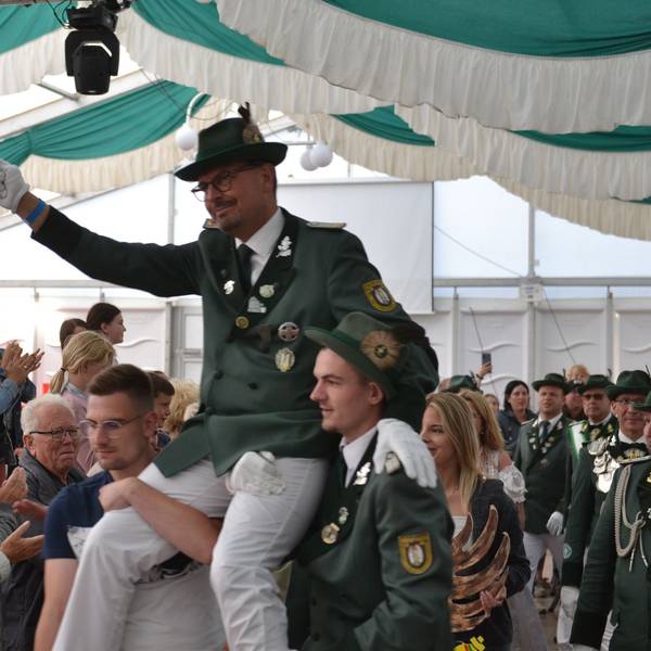 Der neue Schützenkönig wird auf den Schultern durch das Festzelt getragen.