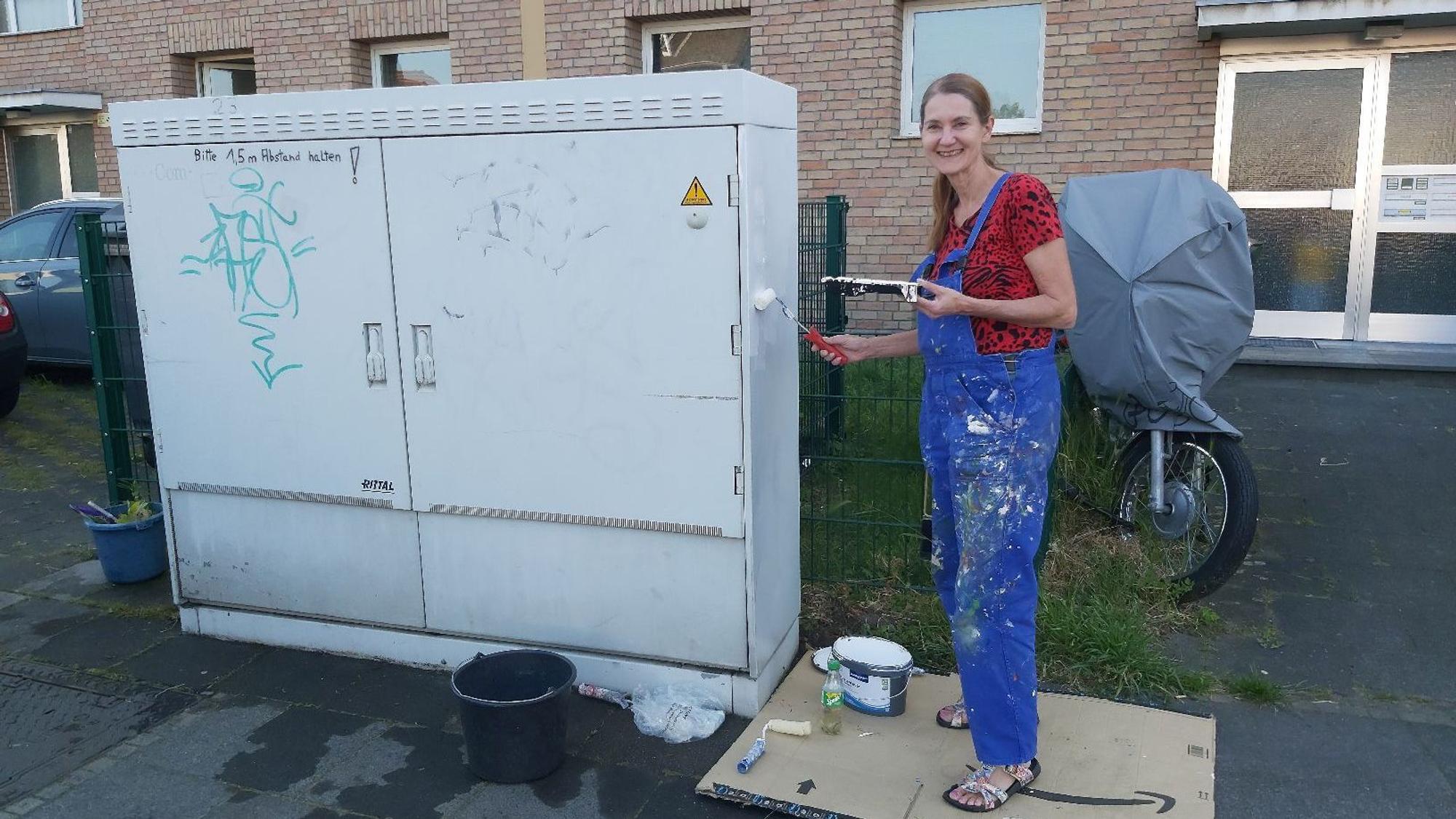 Marina Hahnemann-Schramm bemalt einen Stromkasten.