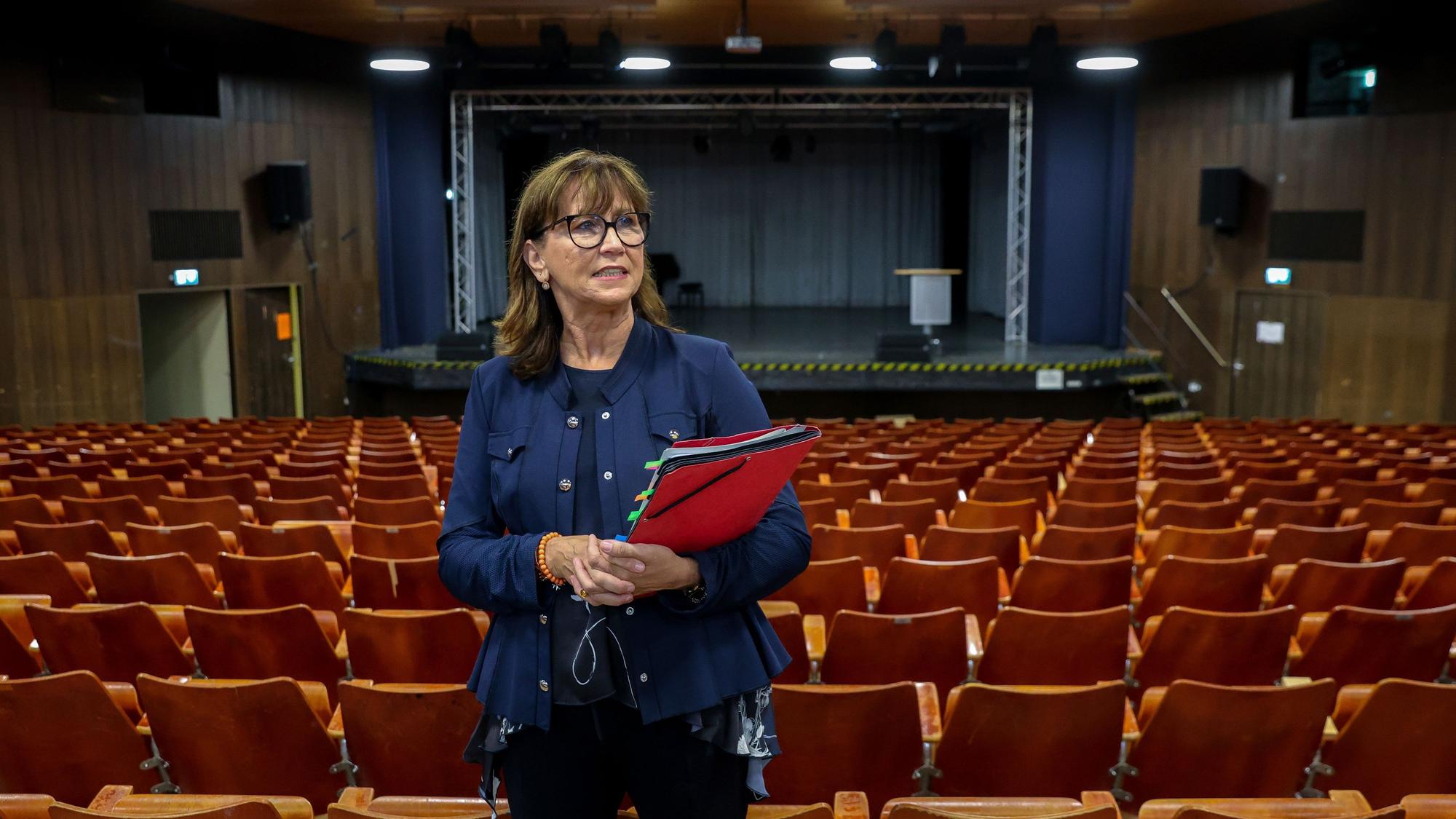 Eine Frau steht mitten in der Aula.