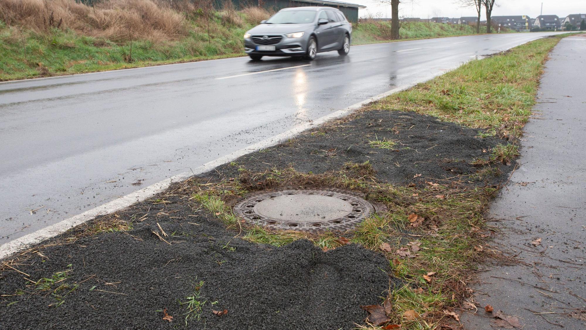 Neben einer Landstrasse in Niederkassel-Lülsdorf befindet sich der Gully, in dem im März 2023 die Leiche entdeckt wurde.