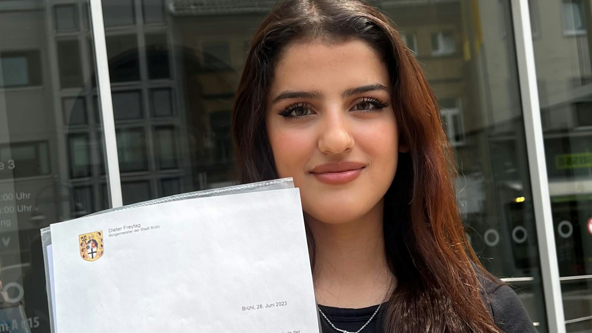 Das Foto zeigt die vor sieben Jahren aus Syrien nach Deutschland geflüchtete Sara Taleb. Sie hält ihr Abiturzeugnis hoch.