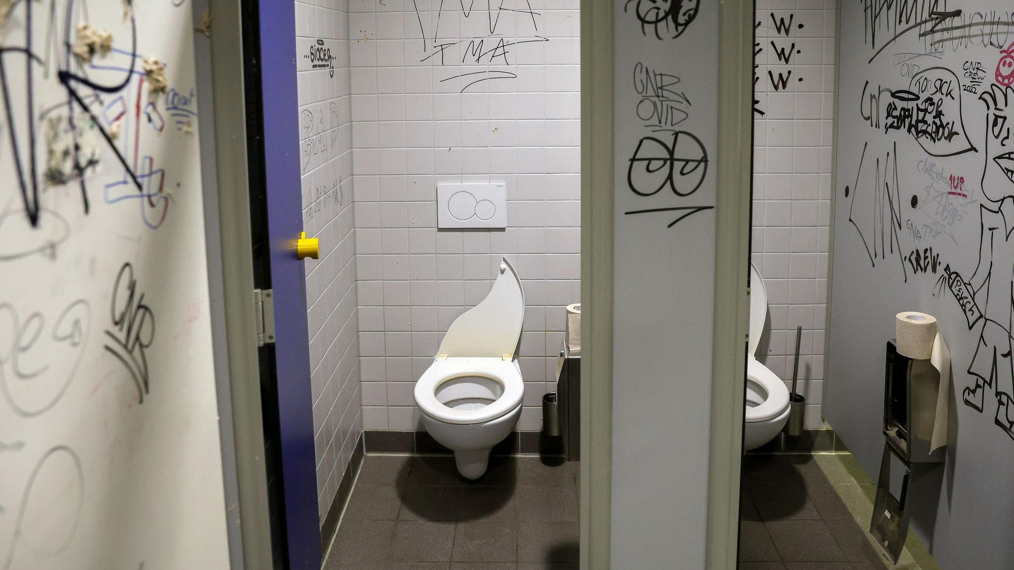Schultoiletten mit Kritzeleien an den Wänden.
