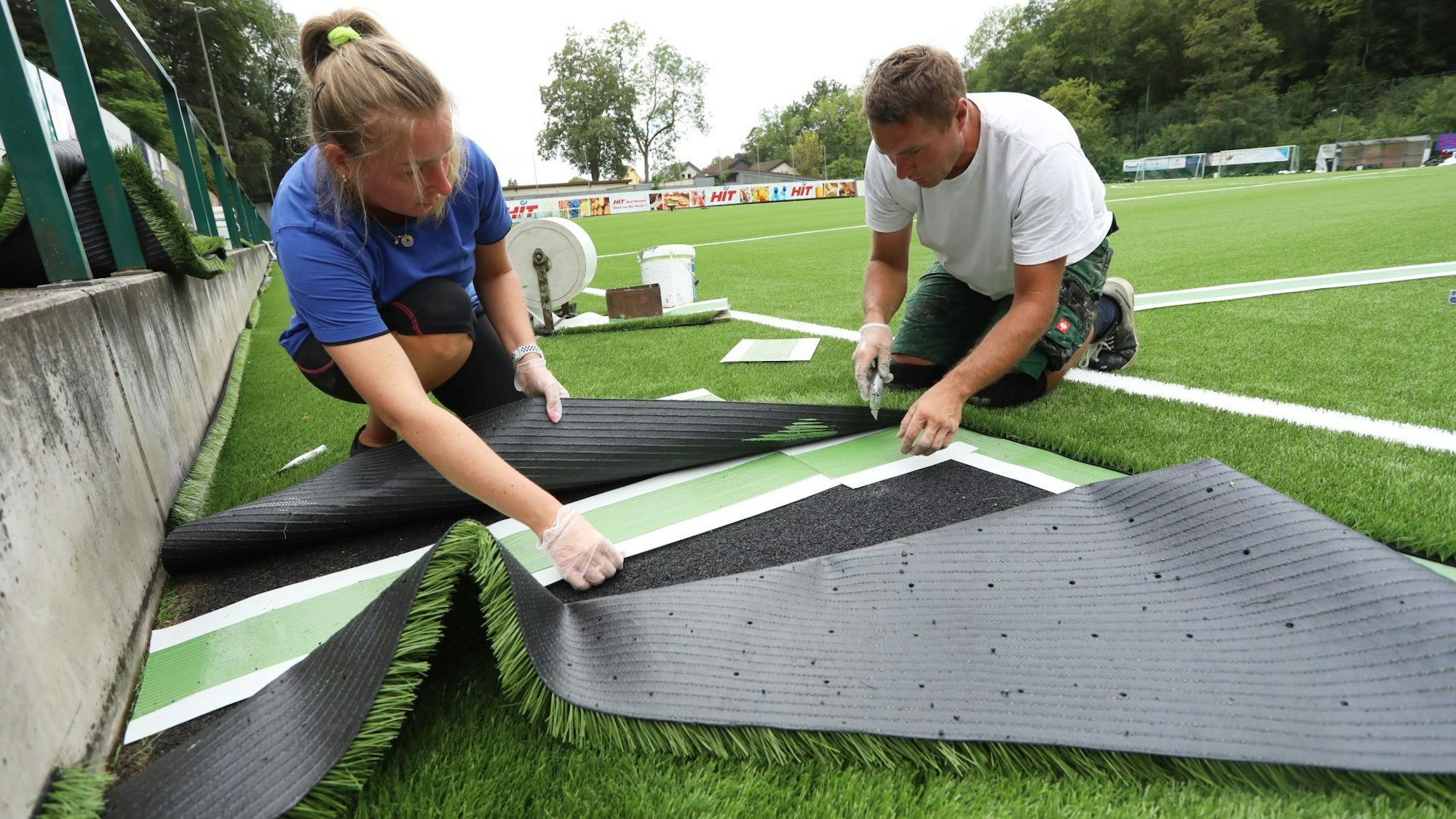 Die weißen Linienstücke werden nachträglich aus dem frisch verlegten Grün rausgeschnitten und danach verklebt.