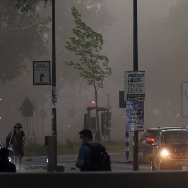 Mehrere Autos fahren mit Scheinwerferlicht durch den Regen in der Kölner Südstadt. Im Hintergrund reißen Sturmböen an den Bäumen. (Symbolbild)