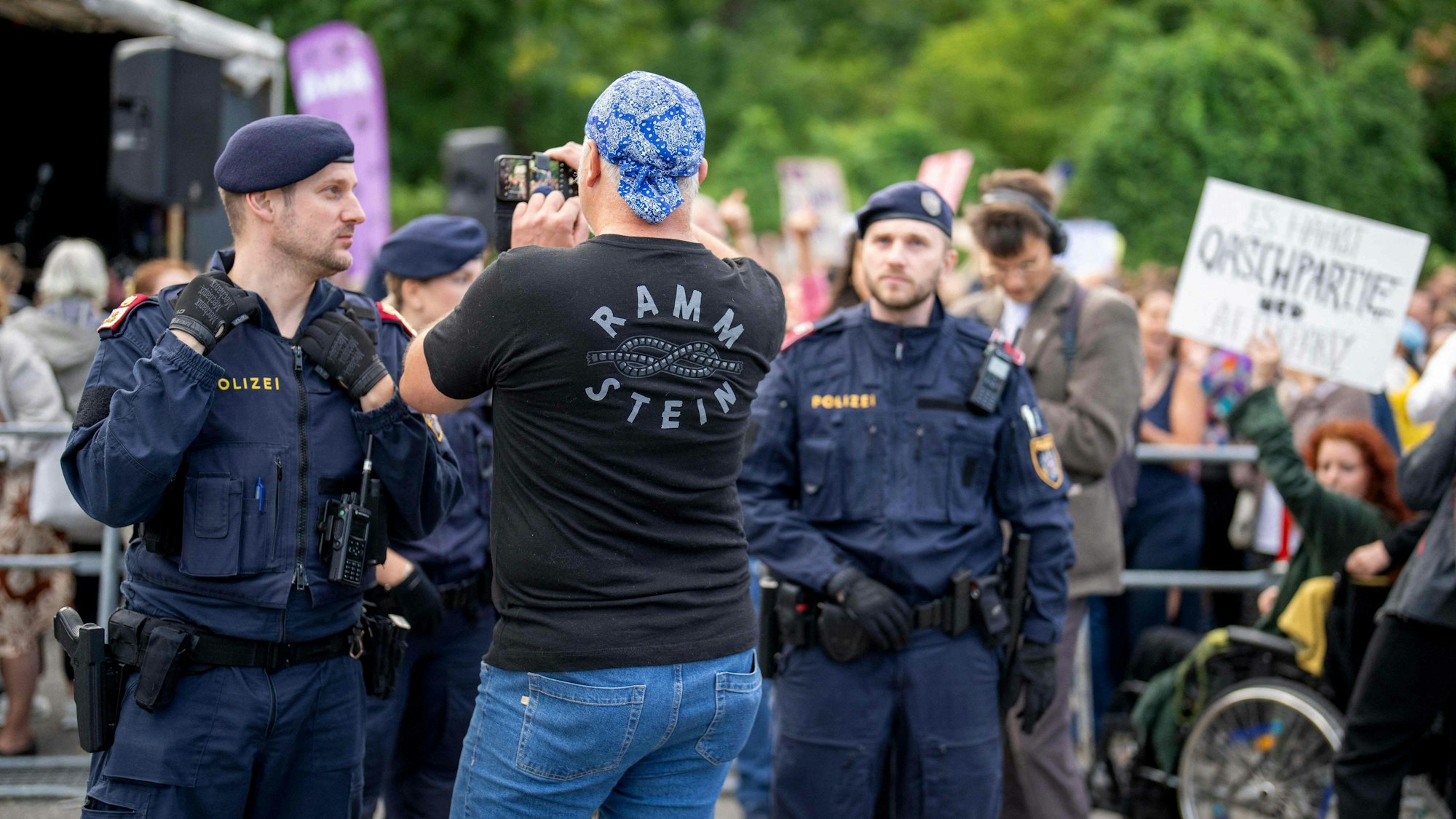 Rammstein-Fan vor Polizisten und Demonstranten in Wien. Nach dem Konzert am Dienstag im Ernst-Happel-Stadion kam es zu Attacken auf Journalisten.