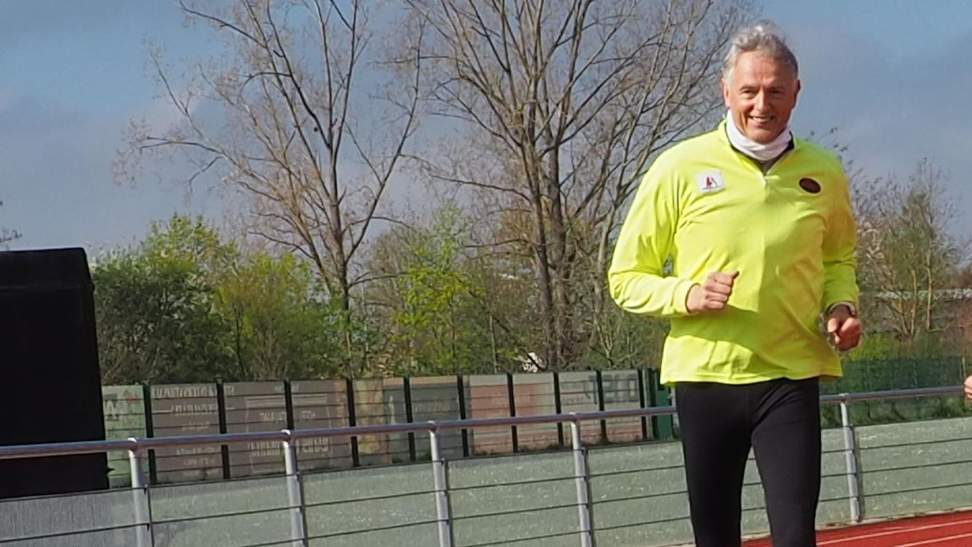 Ein Mann läuft auf einem Sportplatz.