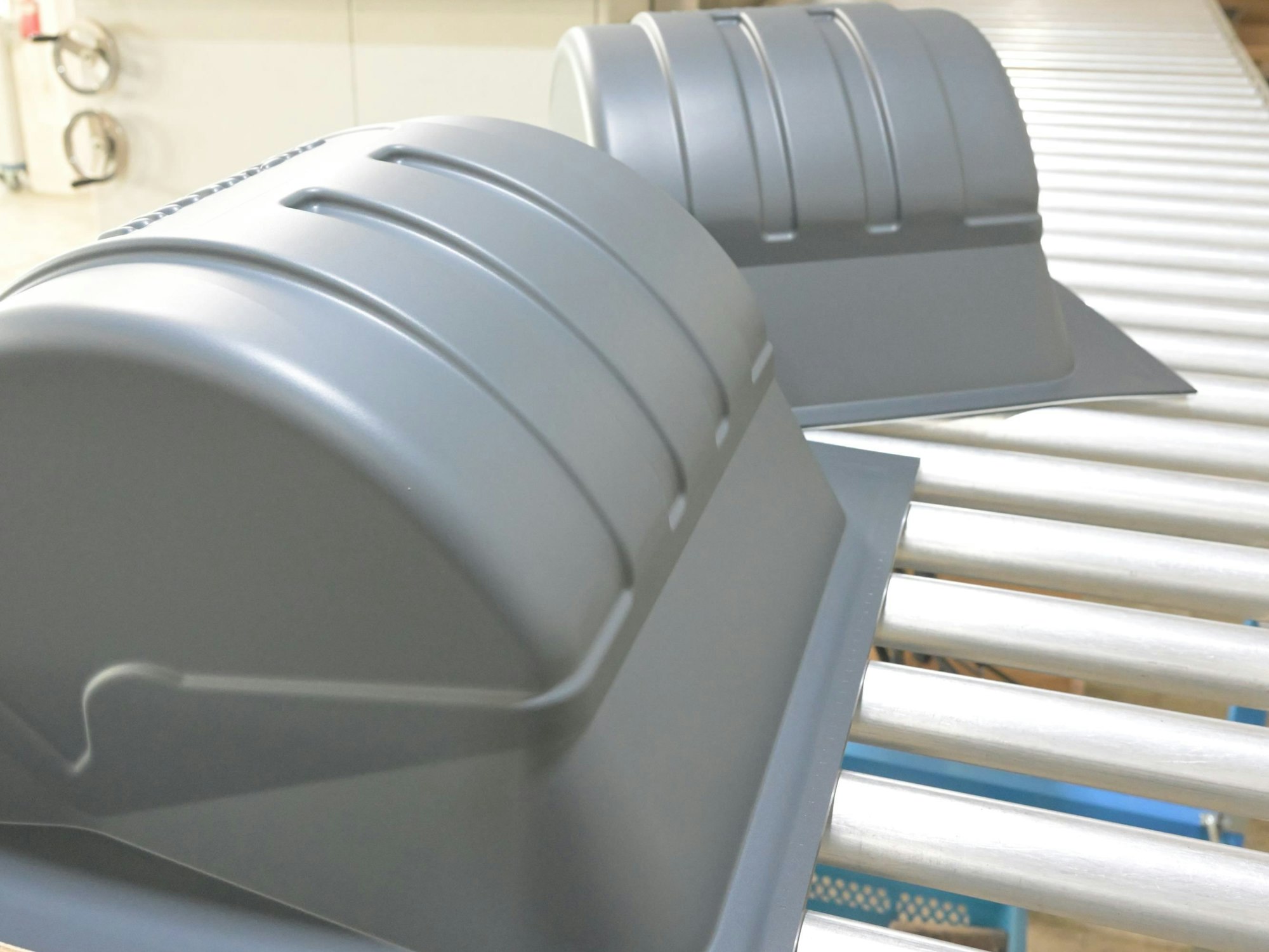 Frisch geformte Abdeckungen verlassen die Thermoform-Maschine.