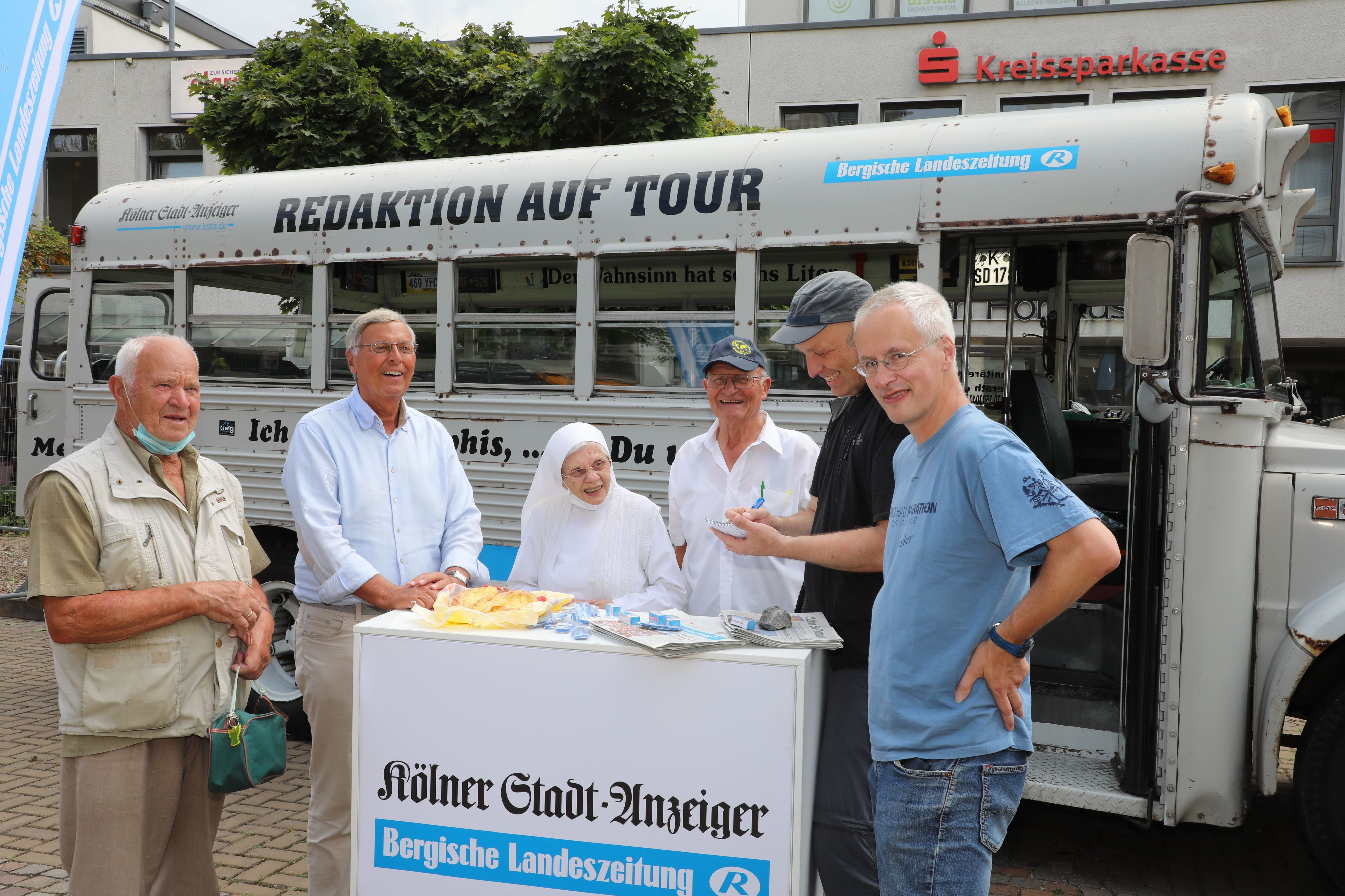 Wolfgang Bosbach und Schwester Regina stehen mit Redaktionsmitgliedern vor dem Bus.