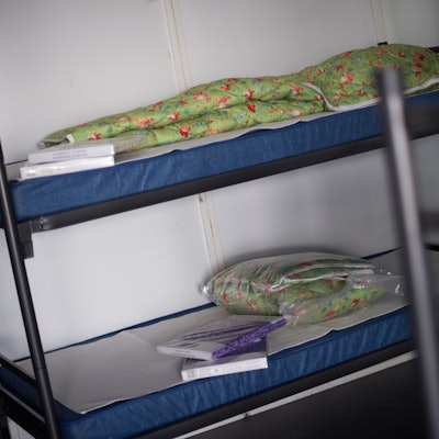 Auf einem Stockbett liegen eingeschweißte Bettbezüge.