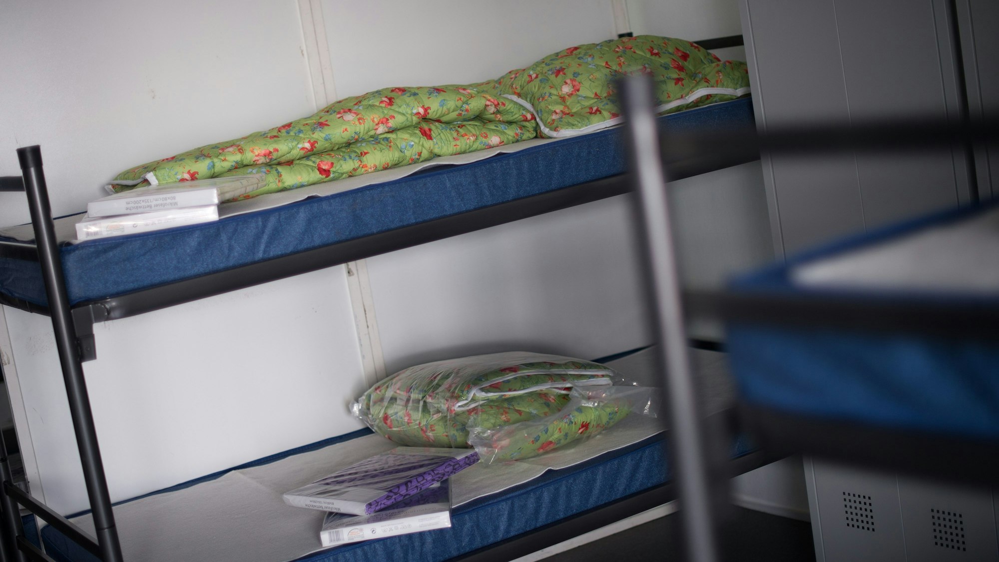 Auf einem Stockbett liegen eingeschweißte Bettbezüge.