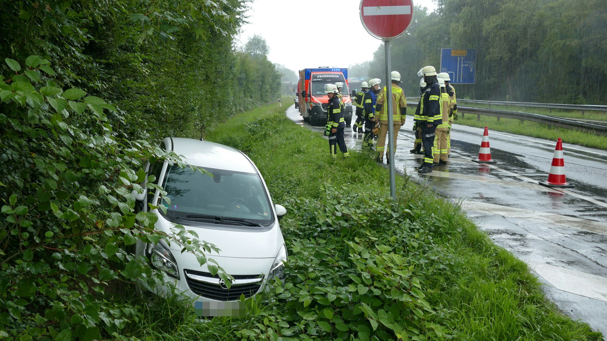 Ein Auto liegt im Straßengraben. Daneben stehen Feuerwehrleute und sichern die Unfallstelle.