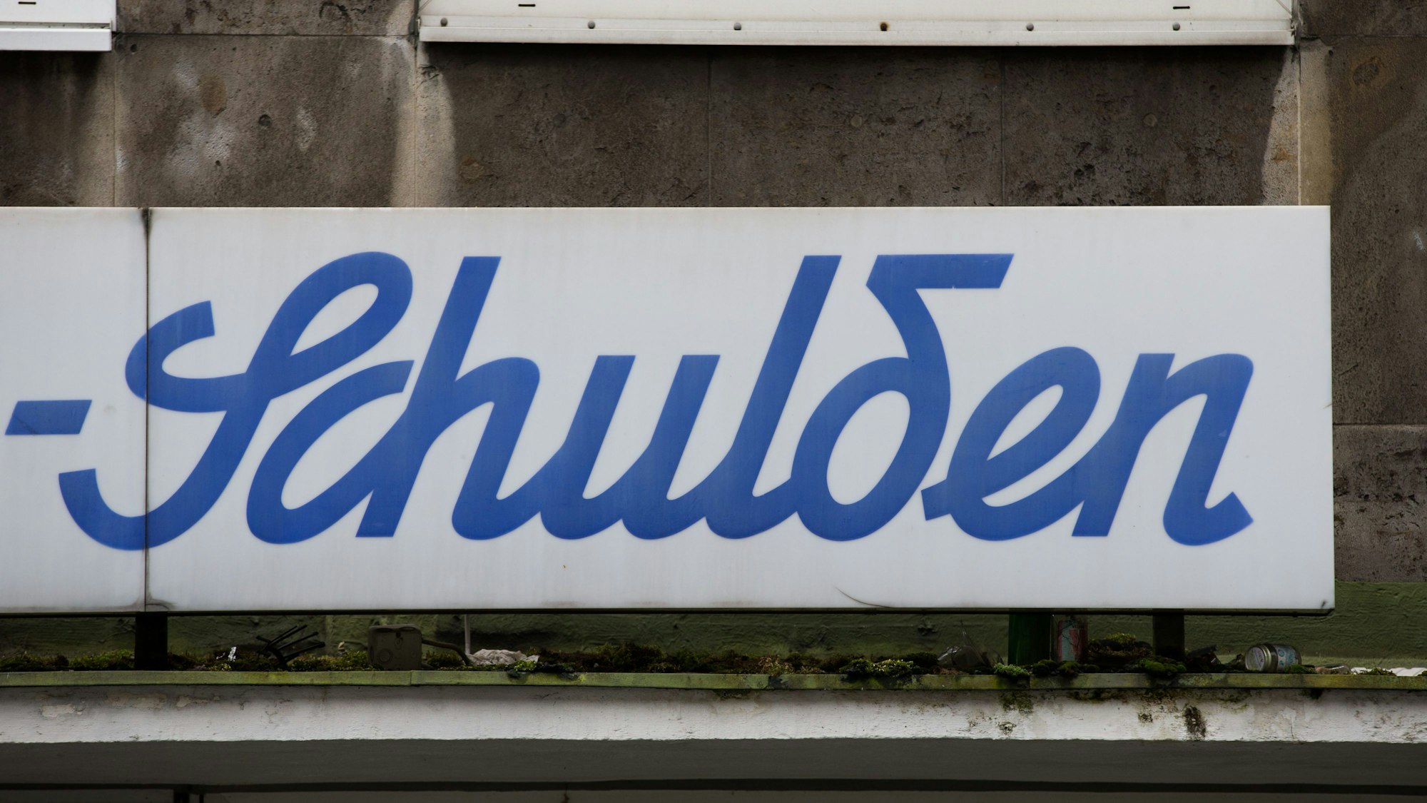 ILLUSTRATION - Der Schriftzug «Schulden» ist am Hauptbahnhof über einem leeren Ladenlokal zu lesen.
