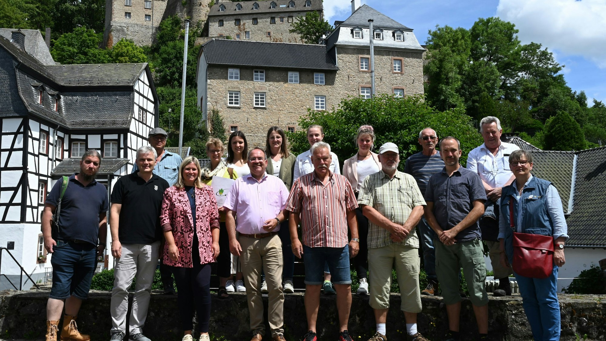 Mehrere Frauen und Männer in Wanderkleidung in einer Stadt mit mittelalterlicher Bebauung.