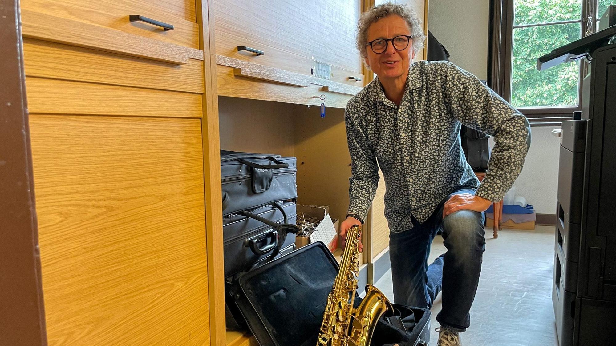 Maximilian Zelzner, Leiter der Musikschule Leichlingen, nimmt ein Saxofon in die Hand.