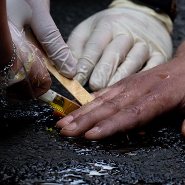 Polizeibeamte entfernen die festgeklebte Hand eines Klimaaktivisten der Gruppe „Letzte Generation“ mit Olivenöl von einer Straße. Nur wenige Minuten nach dem Freispruch für fünf Mitglieder der „Letzten Generation“ vom Vorwurf der Nötigung haben die Klimaaktivisten eine Hauptverkehrsstraße blockiert. Zehn Frauen und Männer setzten sich auf eine Kreuzung und protestierten gegen die Folgen der Klimakrise.
