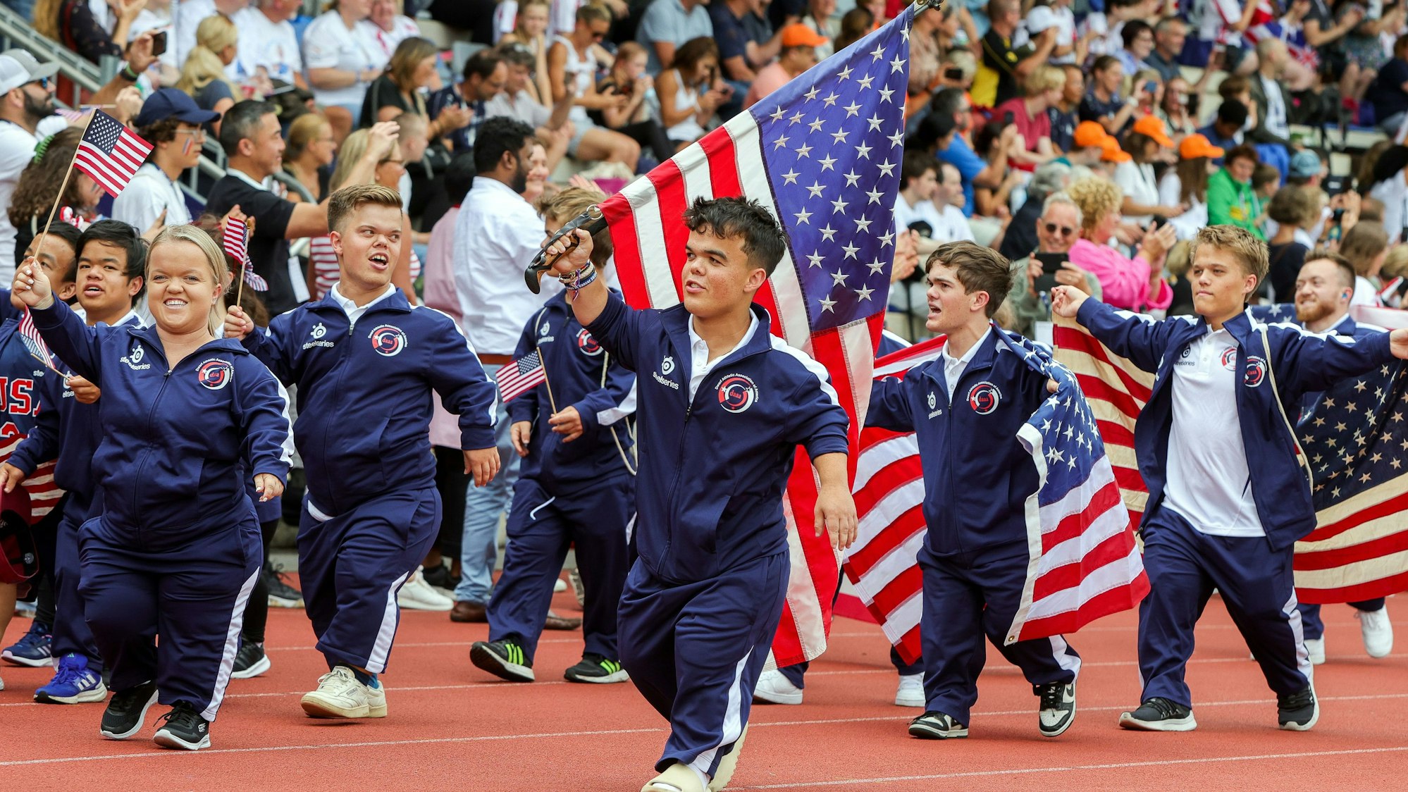 Zu sehen ist das ein Teil der amerikanischen Athletinnen und Athleten bei der Eröffnungsfeier der World Dwarf Games Cologne im NetCologne Stadion der Deutschen Sporthochschule Köln.