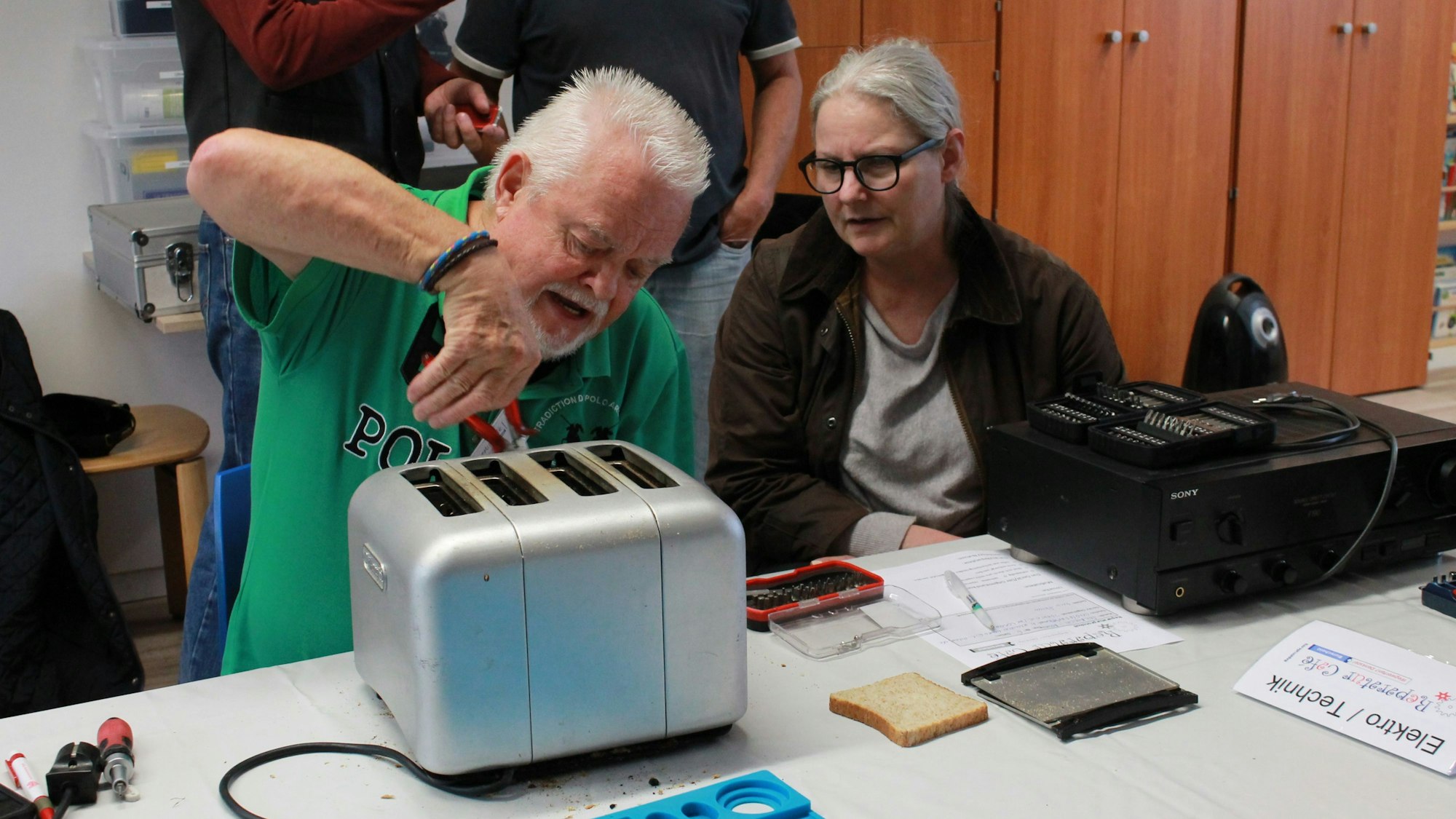Reparateur Johannes Kurzawa versucht, den Toaster von Kundin Brigida Selmeczi-Bowen ans Laufen zu bringen.
