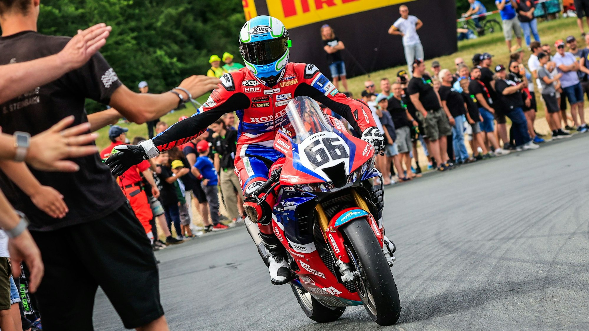 Florian Alt klatscht nach seinem ersten Sieg in Schleiz die Fans ab.
