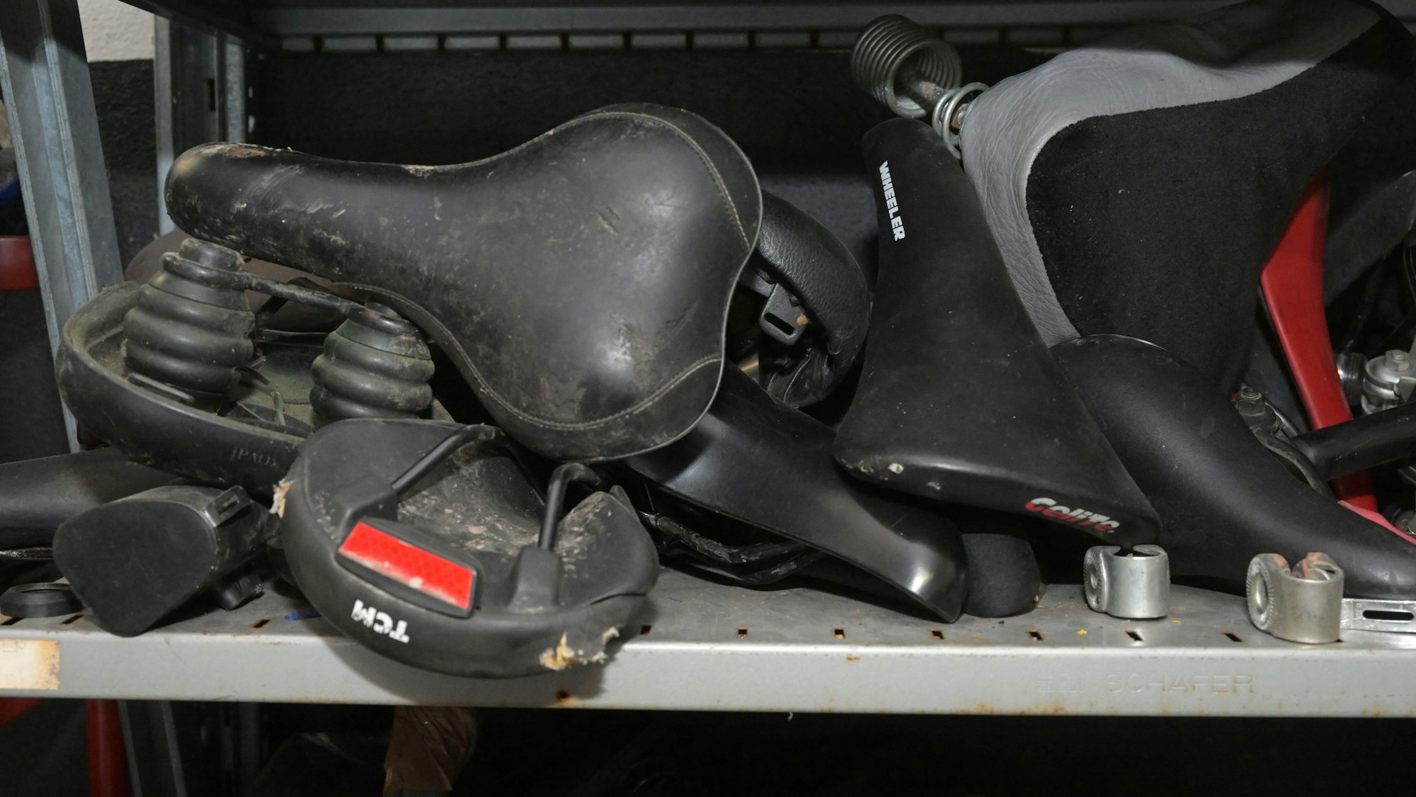 In einem Fach liegen Radsätteln nebeneinander.