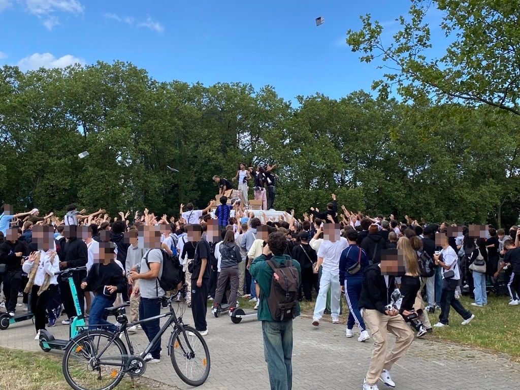 Mitarbeiter von None of us verteileln Klamotten an der Uniwiese in Köln.