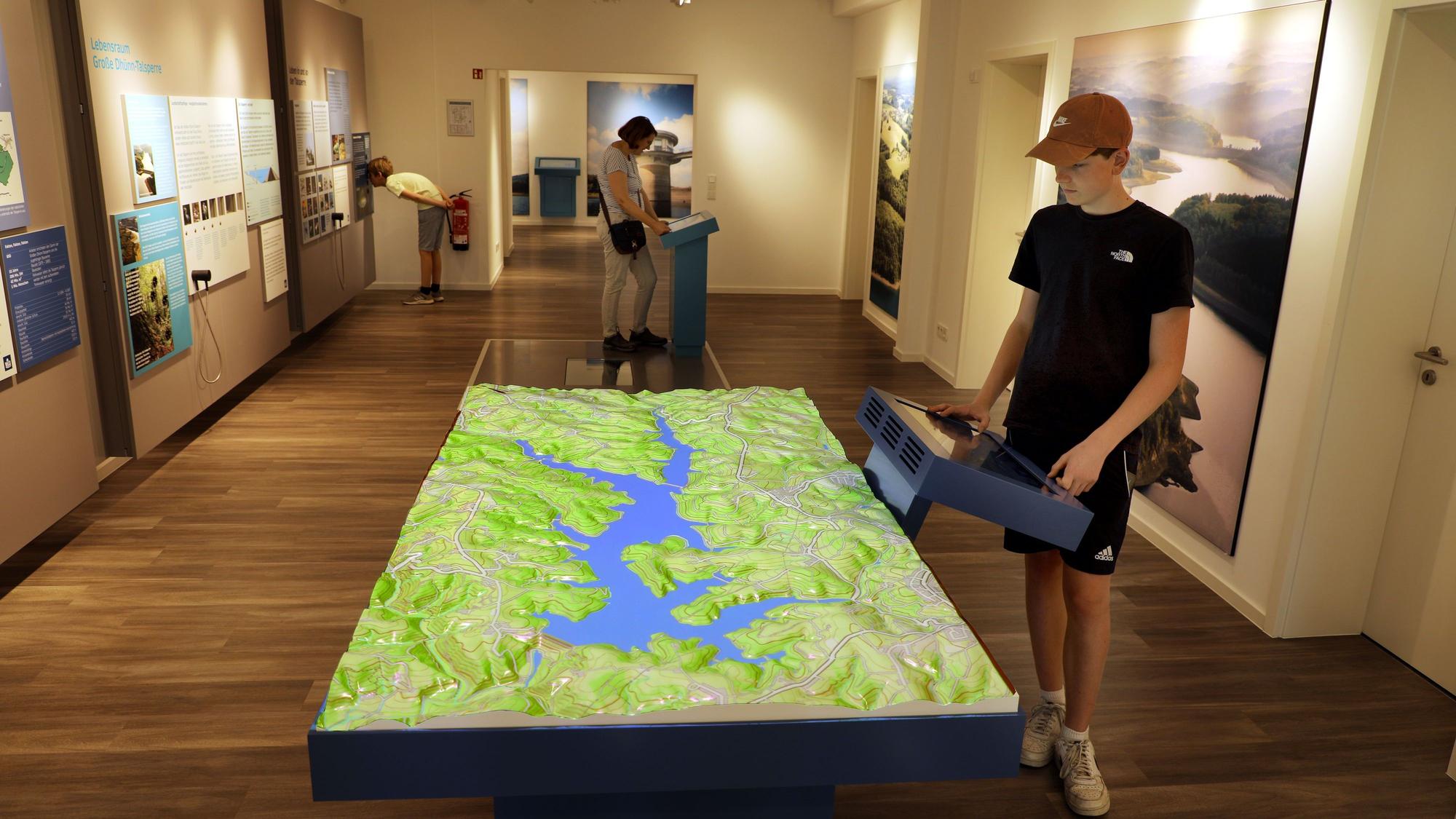 Menschen besichtigen eine Infoausstellung zum Thema Wasser des Vereins Aqualon an der Großen Dhünn-Talsperre.