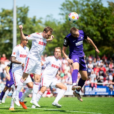Das Bild zeigt den 1. FC Köln im Spiel gegen Aue. Der Ball wird per Kopf geklärt.