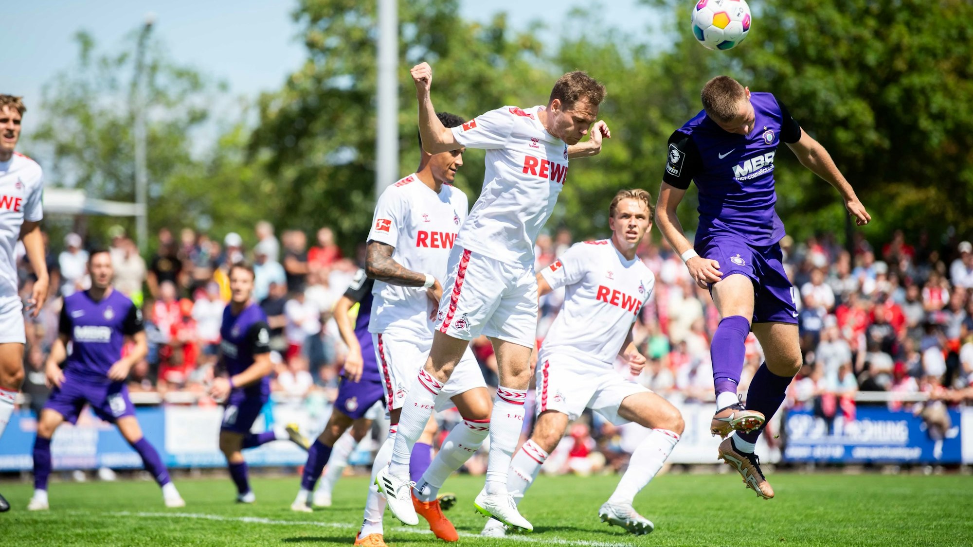 Das Bild zeigt den 1. FC Köln im Spiel gegen Aue. Der Ball wird per Kopf geklärt.