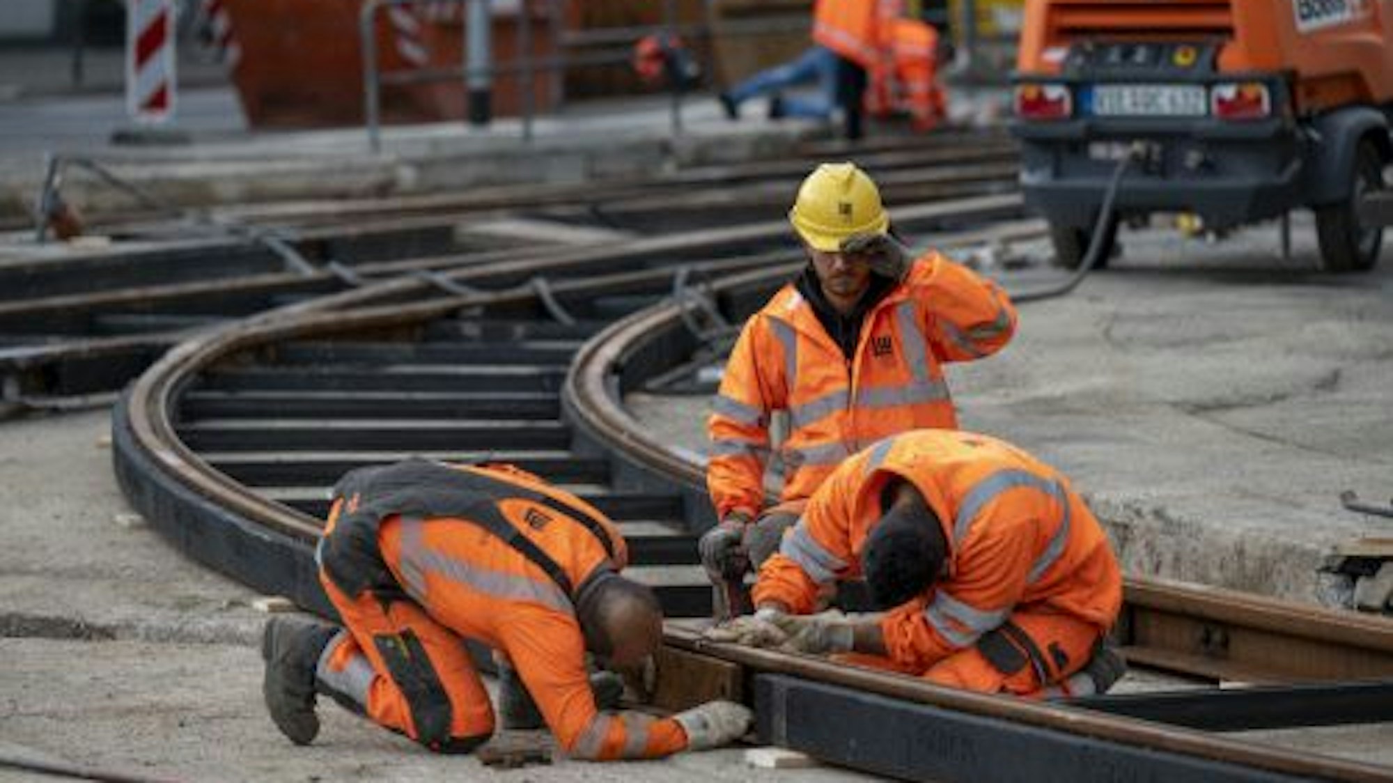 Bauarbeiter verlegen an der Kreuzung Aachener Straße/Gürtel Schienen für die Stadtbahn.