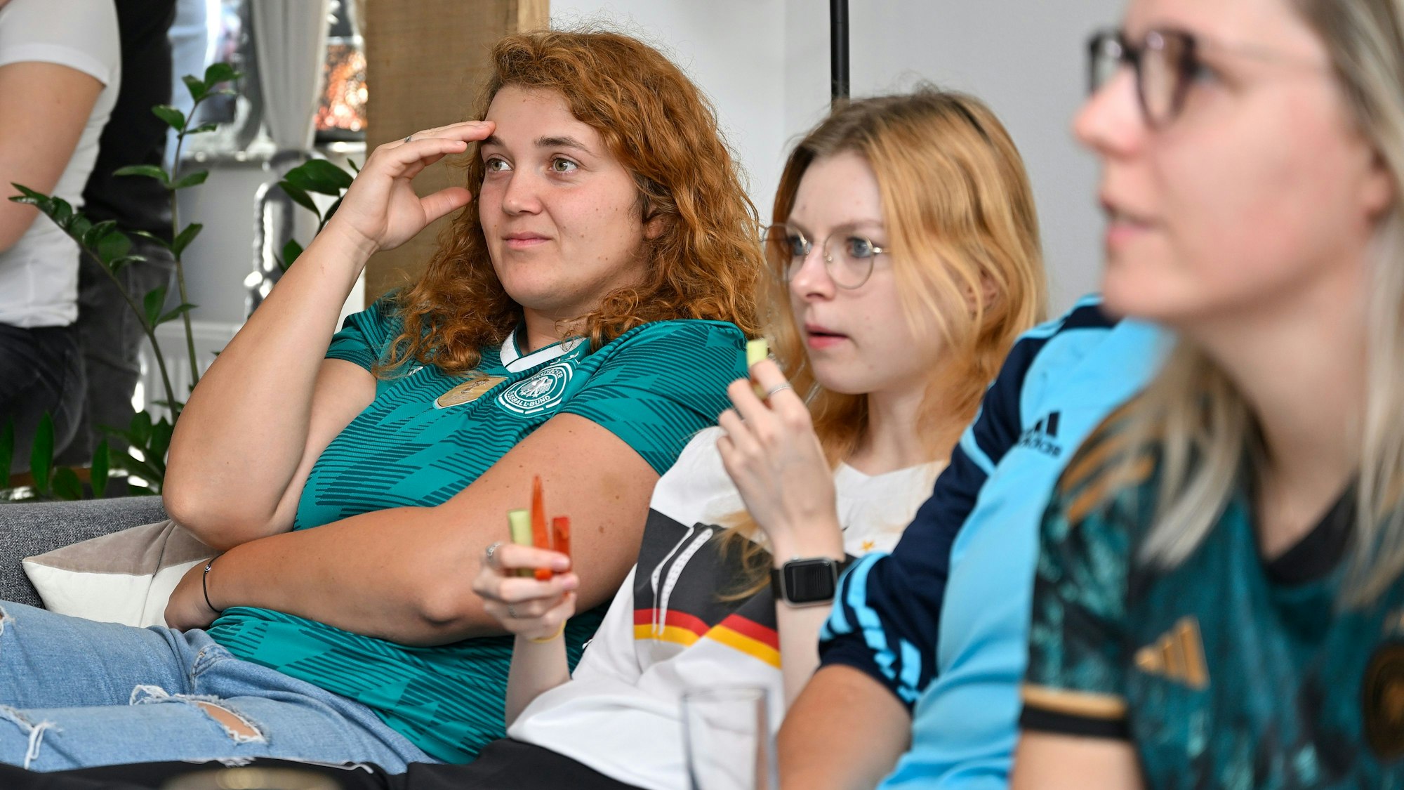 Frauen des schauen auf den Fernseher und schauen enttäuscht.