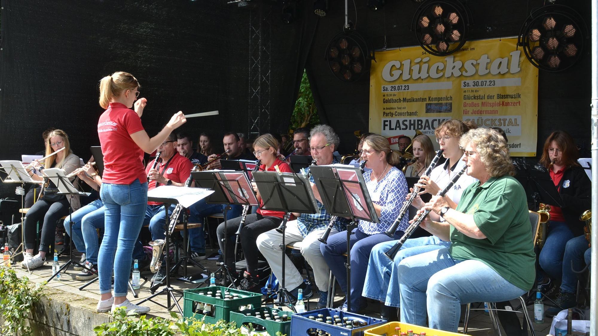 Das Foto zeigt eine Dirigentin vor einem Orchester.