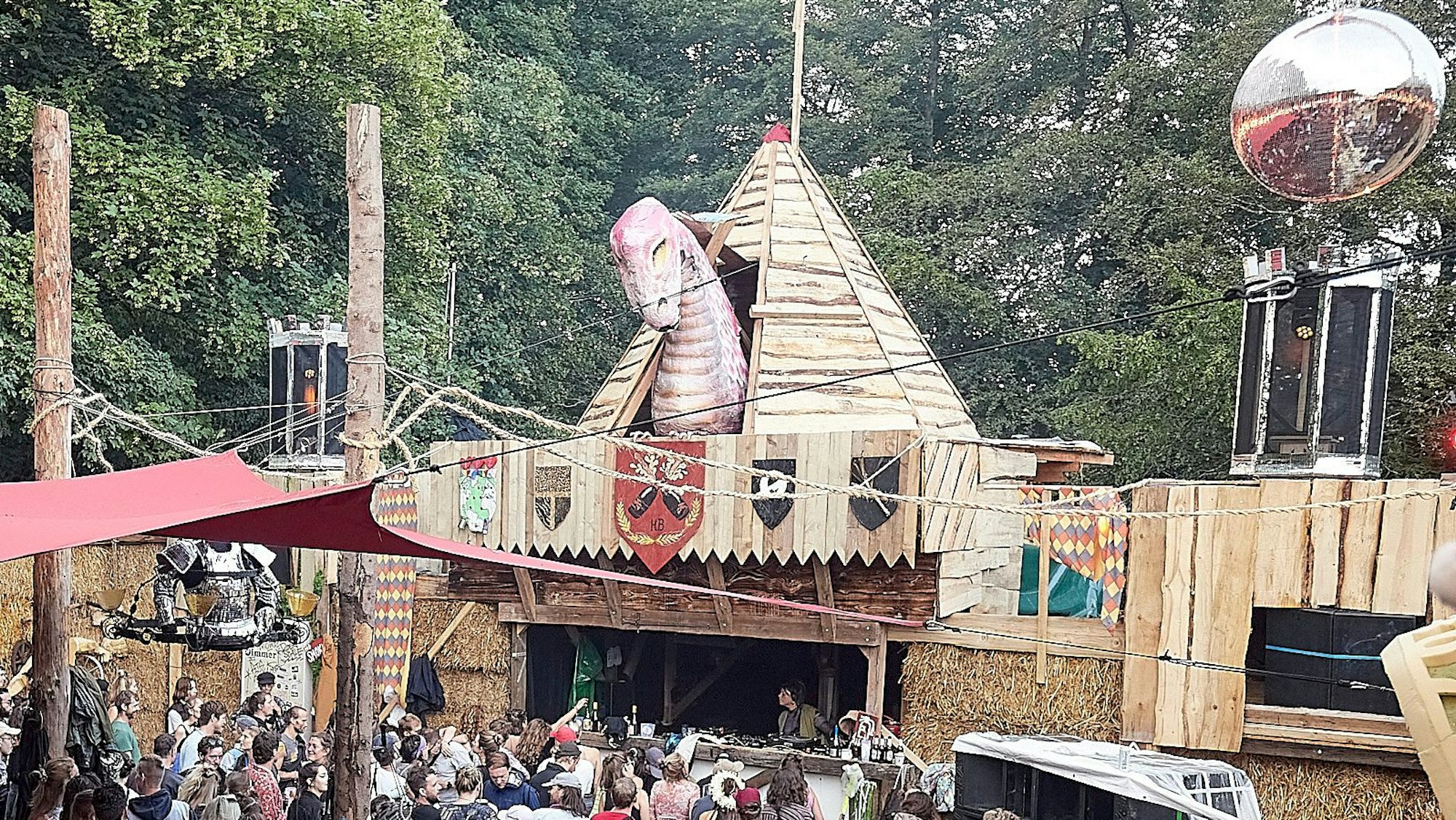 Aufwendig ist das gesamte Festival-Gelände gestaltet, hier eine Tanzarena, die mit einer großen Dinosaurier-Figur dekoriert ist.
