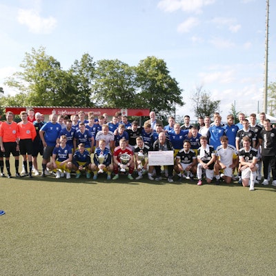 Die beiden Mannschaften des Endspiels, SSV Nümbrecht und Borussia Derschlag stehen in der Spielfeldmitte zum Foto.