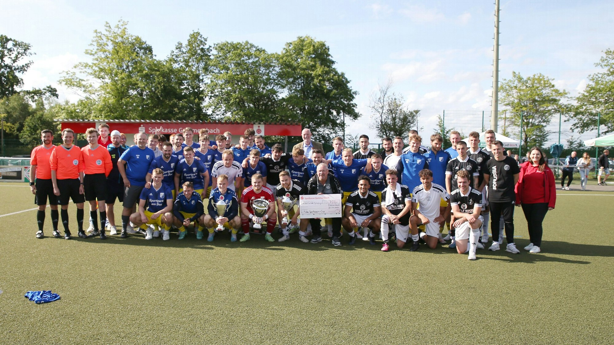Die beiden Mannschaften des Endspiels, SSV Nümbrecht und Borussia Derschlag stehen in der Spielfeldmitte zum Foto.