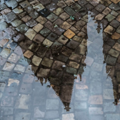 Der Kölner Dom spiegelt sich in einer Pfütze.