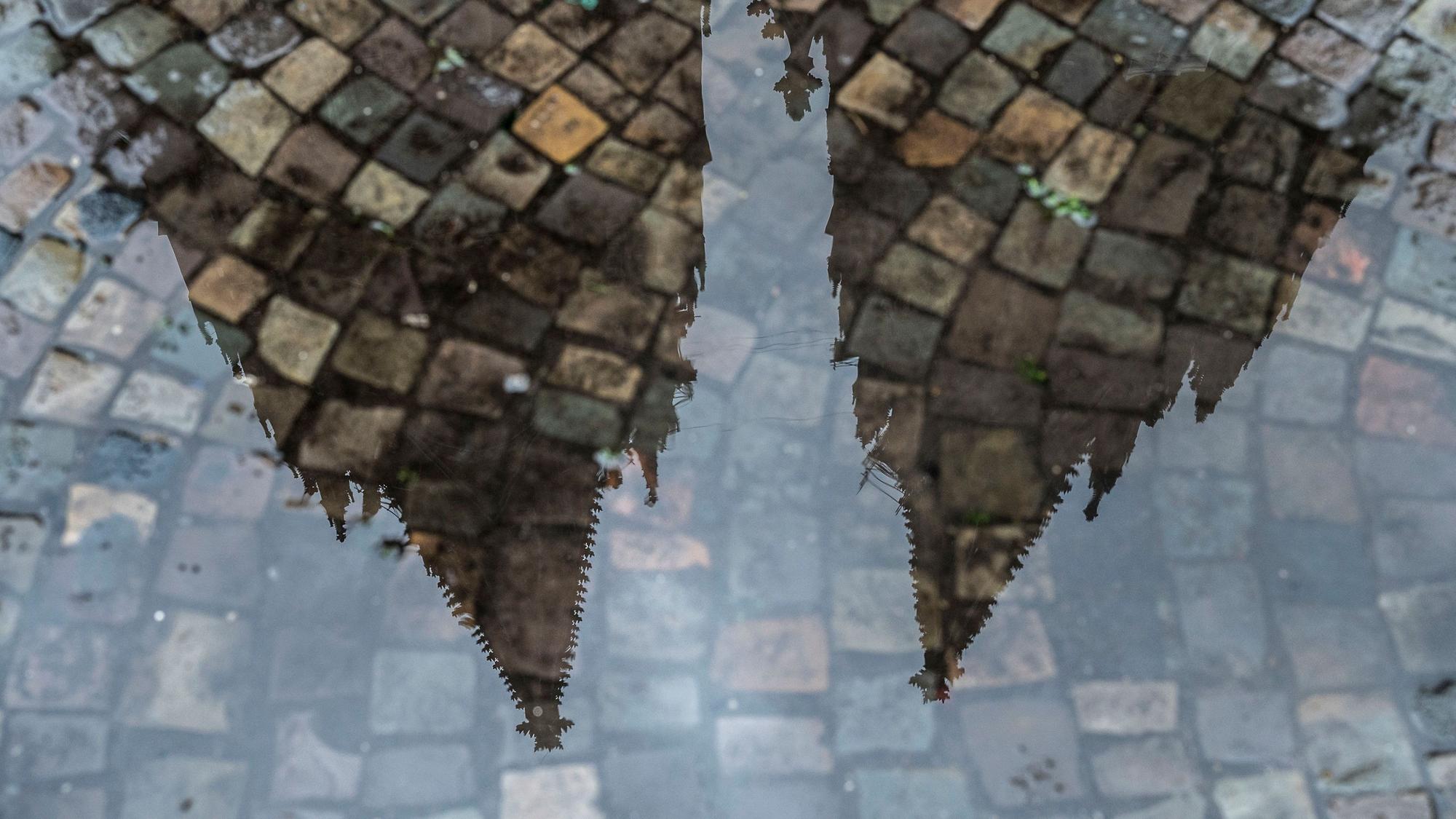 Der Kölner Dom spiegelt sich in einer Pfütze.