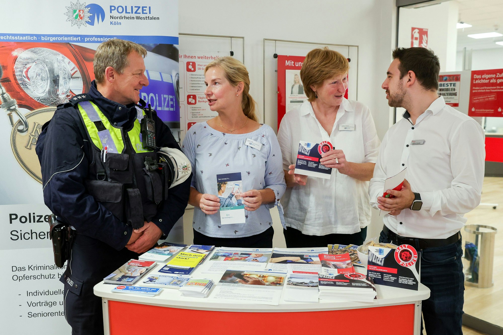Herbert Schmitz (v. l.), Sigrid Jung, Gudrun Krämer und Stephan Henseler stehen am Infostand in der Sparkassenfiliale in Köln-Dellbrück.