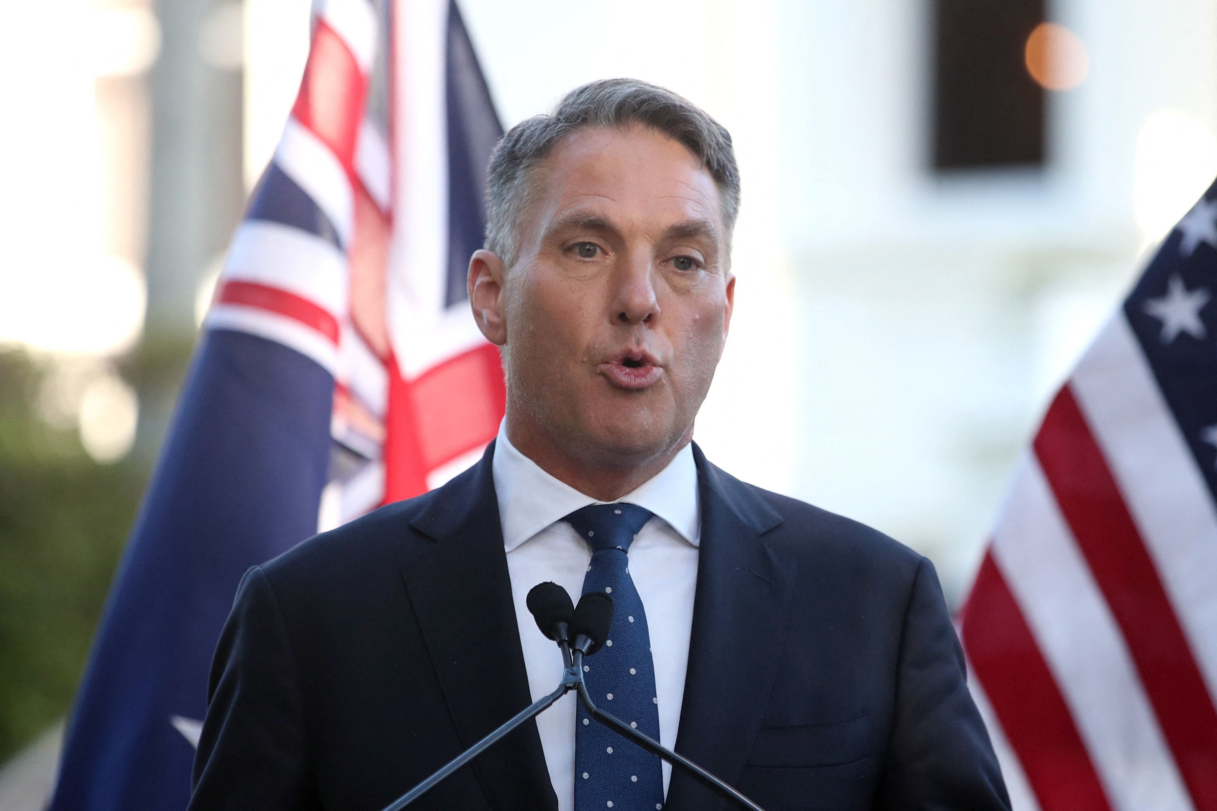 Australiens Verteidigungsminister Minster Richard Marles spricht vor einer australischen und amerikanischen Flagge auf einer Pressekonferenz. (Symbolbild)