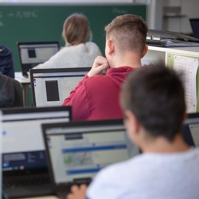 Schülerinnen und Schüler nehmen im Klassenzimmer einer 9. Klasse der Gemeinschaftsschule Leutenbach am Geografieunterricht mit Hilfe von Laptops und Tablets teil.