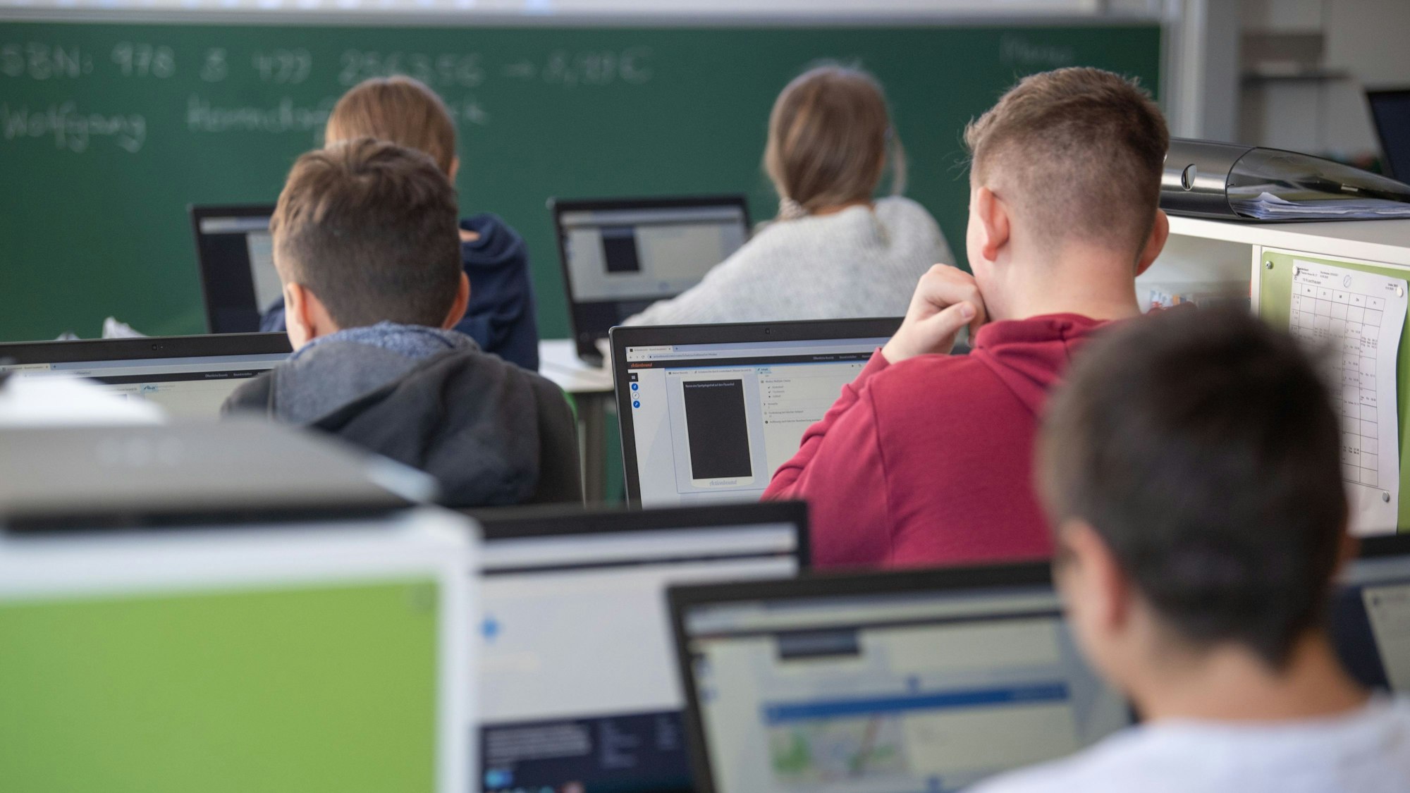 Schülerinnen und Schüler nehmen im Klassenzimmer einer 9. Klasse der Gemeinschaftsschule Leutenbach am Geografieunterricht mit Hilfe von Laptops und Tablets teil.